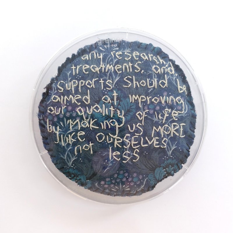 Photo of one petri dish that says 'any research treatments and supports should be aimed at improving our quality of life by making us more like ourselves not less